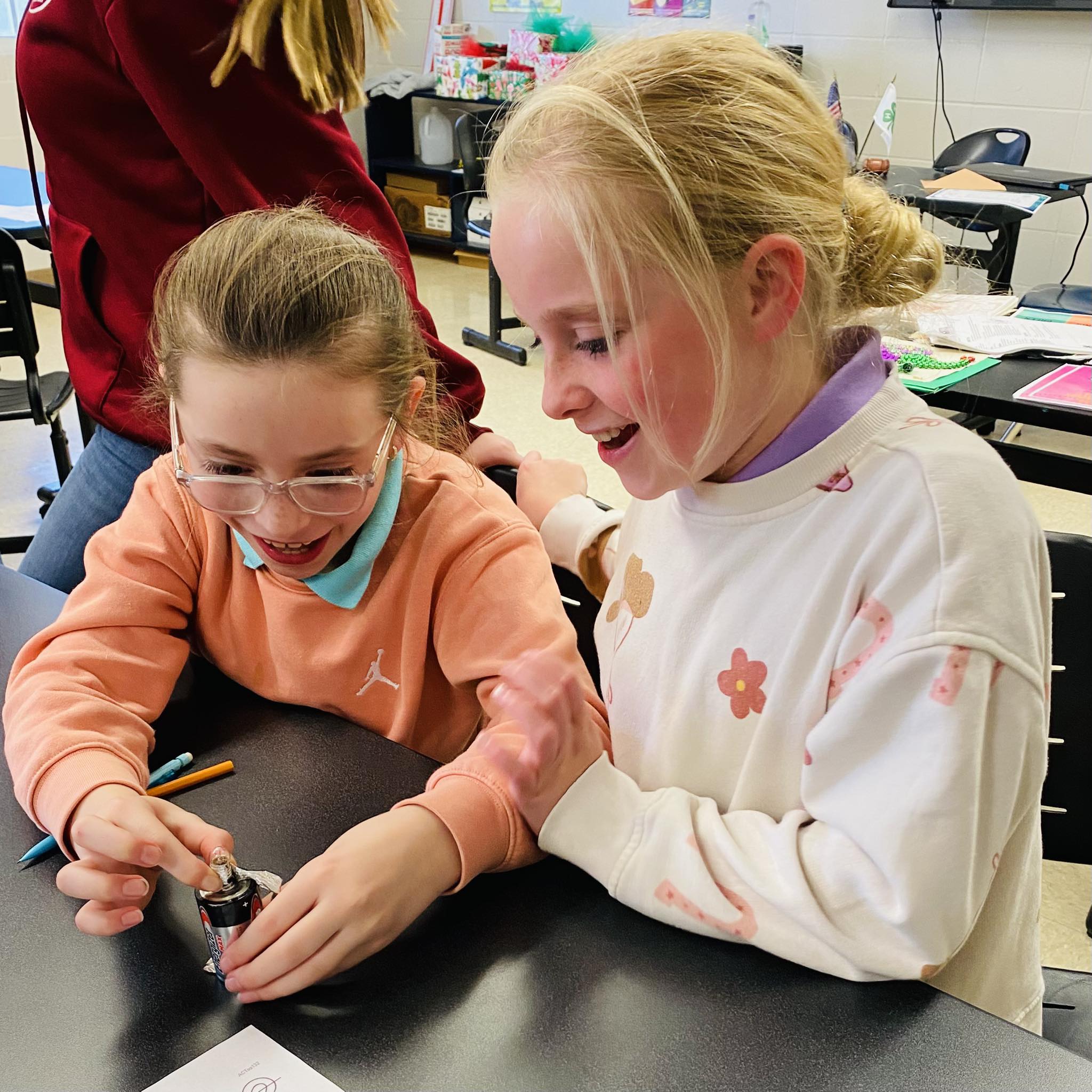 Two girls looking at a tiny light.